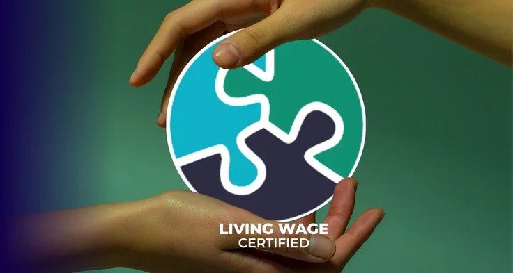 Hands holding a circular logo with interlocking puzzle pieces with Living Wage certified text.