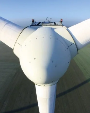 close-up on a wind turbine in a green landscape background